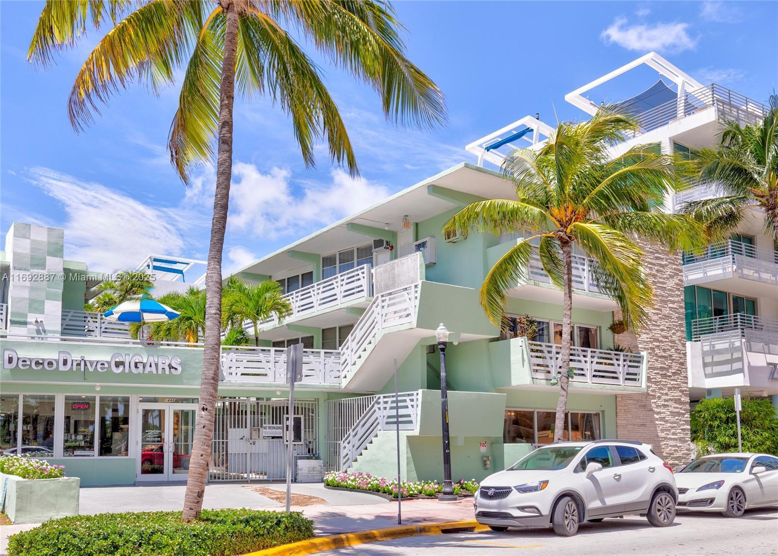 A light green multi-story apartment building with exterior staircases and a ground-floor cigar shop — 1446 Ocean Dr # 2, Miami Beach FL 33139, MIAMI BEACH, FL