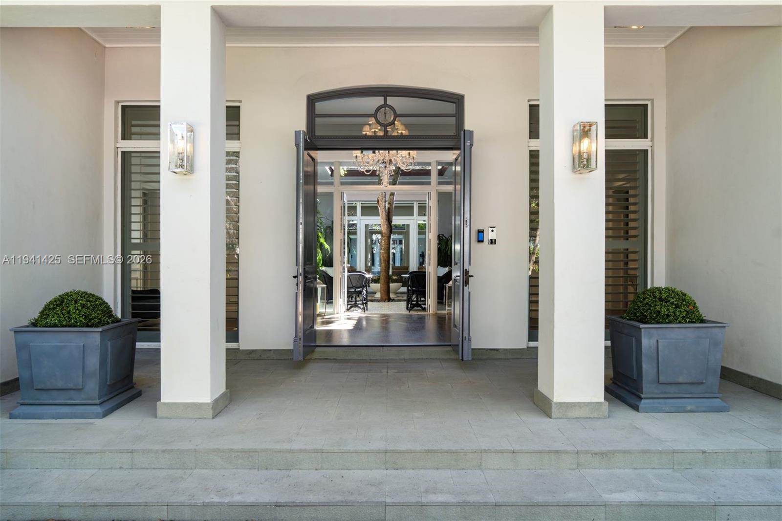 The front entrance features two large planters, stone steps, and a view into a courtyard — 4100 Kiaora St, Miami FL 33133, MIAMI, FL