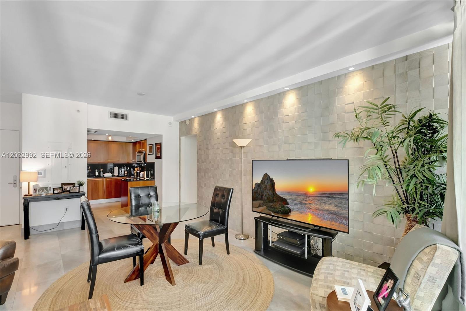 A dining area and living space feature a textured accent wall and a glass table — 1331 Brickell Bay Dr # 1504, Miami FL 33131, MIAMI, FL