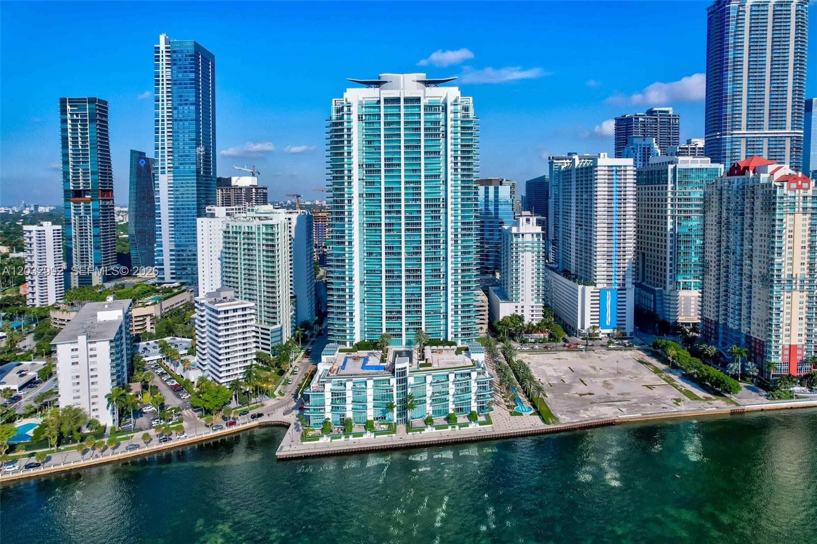 An aerial view of a tall glass residential tower situated on a waterfront in Miami — 1331 Brickell Bay Dr # 1504, Miami FL 33131, MIAMI, FL