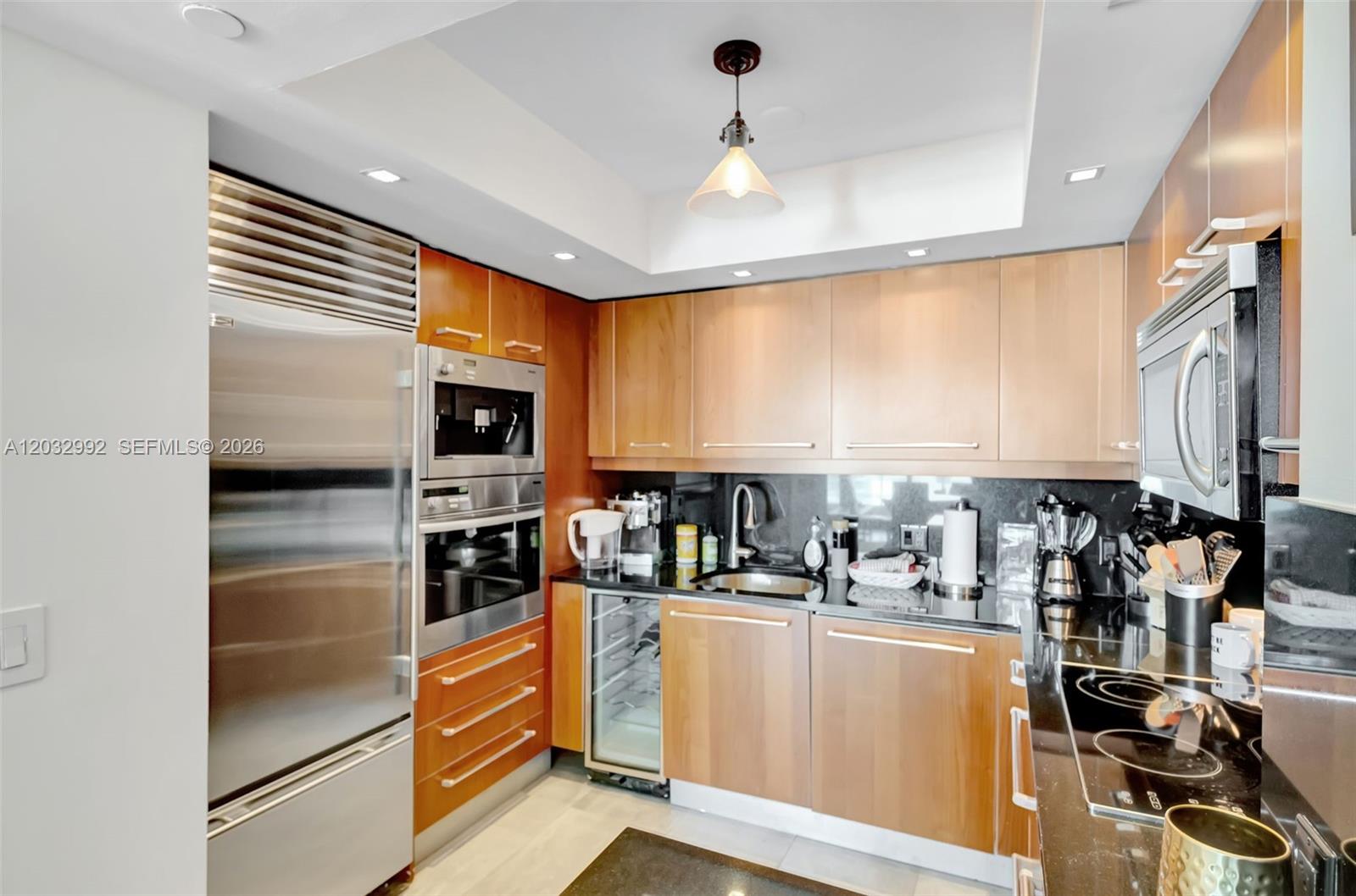A kitchen features light wood cabinets, stainless steel appliances, and black granite countertops — 1331 Brickell Bay Dr # 1504, Miami FL 33131, MIAMI, FL