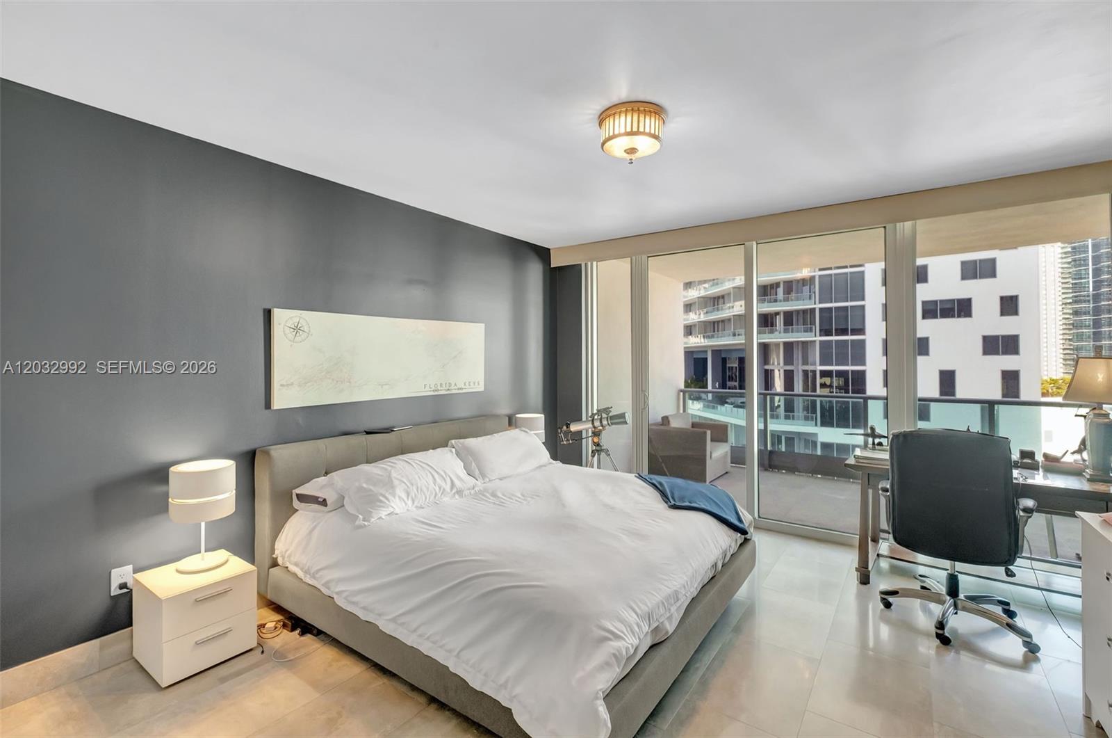 A bedroom features a gray accent wall, a platform bed, and a desk near balcony doors — 1331 Brickell Bay Dr # 1504, Miami FL 33131, MIAMI, FL