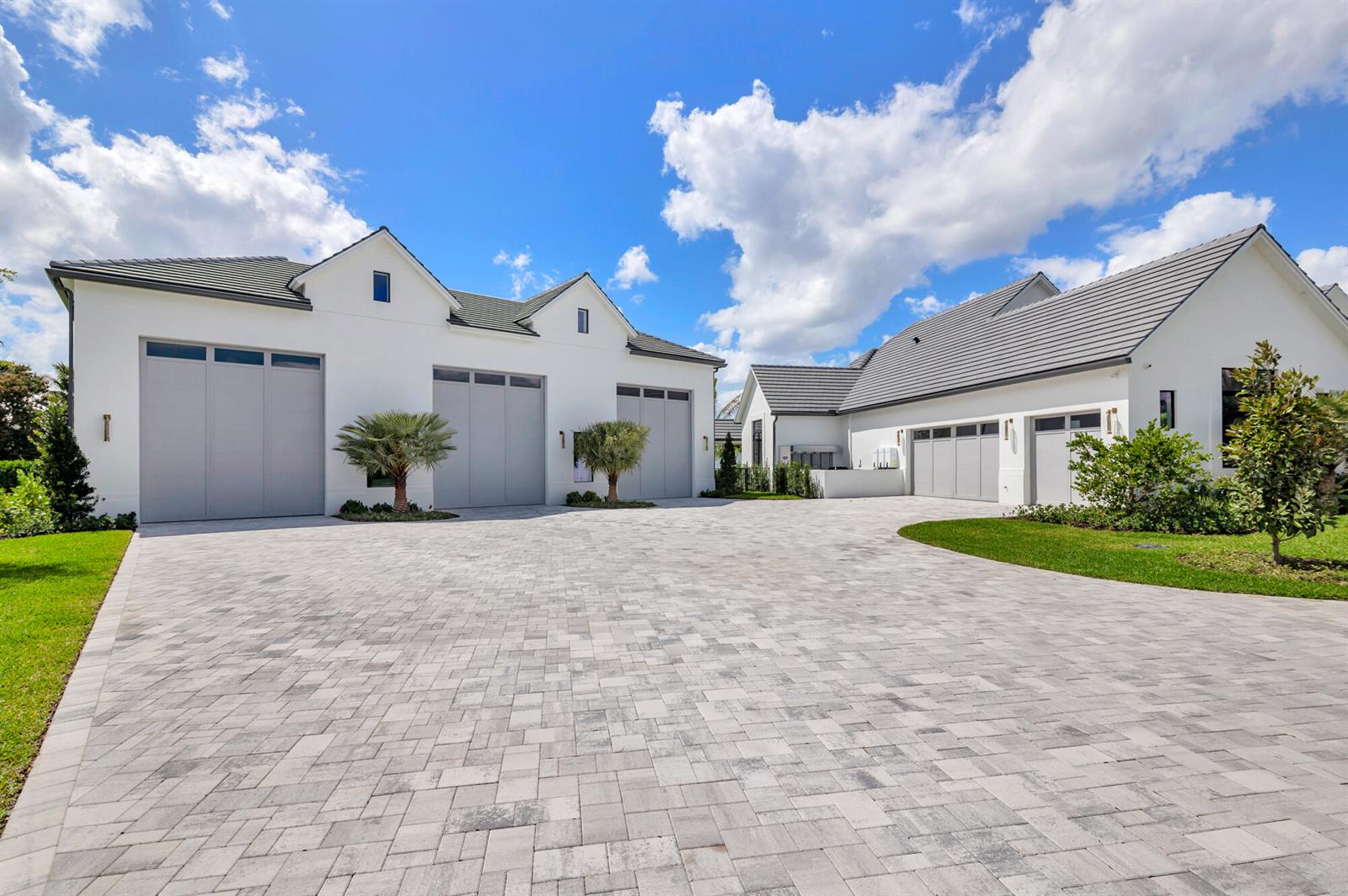 A large white house with a paved driveway and multiple garage doors under a sky — 2015 Lockheed Terrace, Wellington FL 33414, WELLINGTON, FL