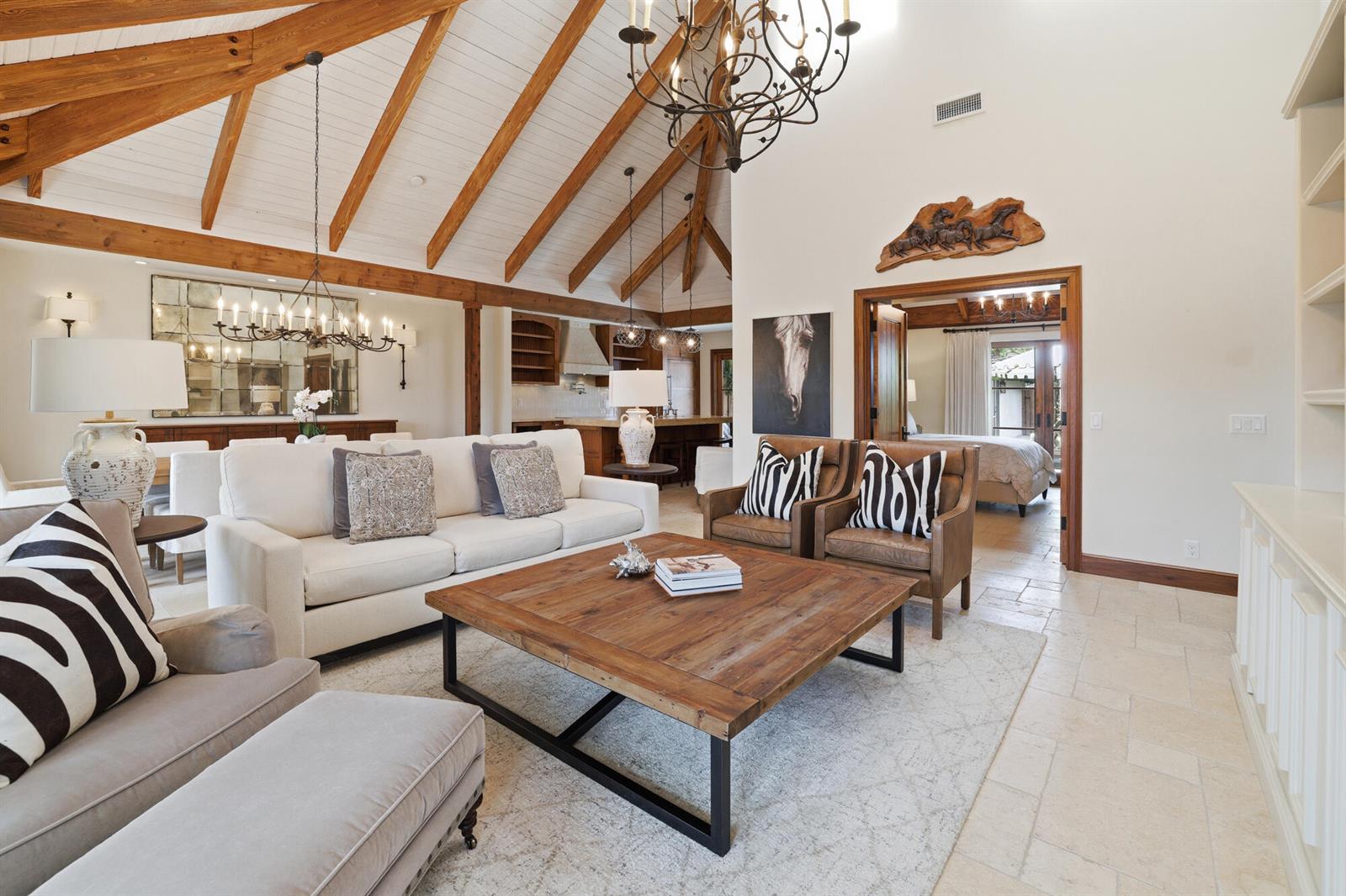 A living room features vaulted wood-beamed ceilings, a large wooden coffee table, and stone flooring — 11760 Marblestone Court, Wellington FL 33414, WELLINGTON, FL