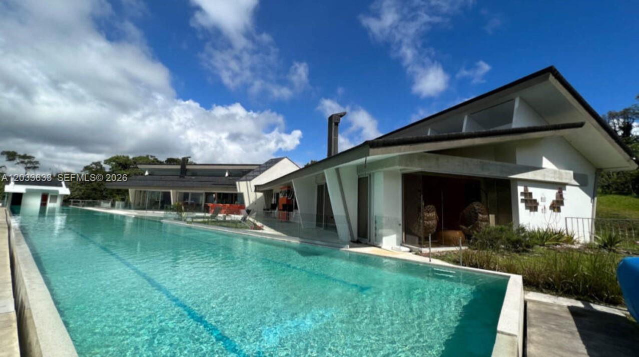 A modern house with a large swimming pool and a sloped roof under a blue sky — Calle Las marias Calle Las marias, FL, FL