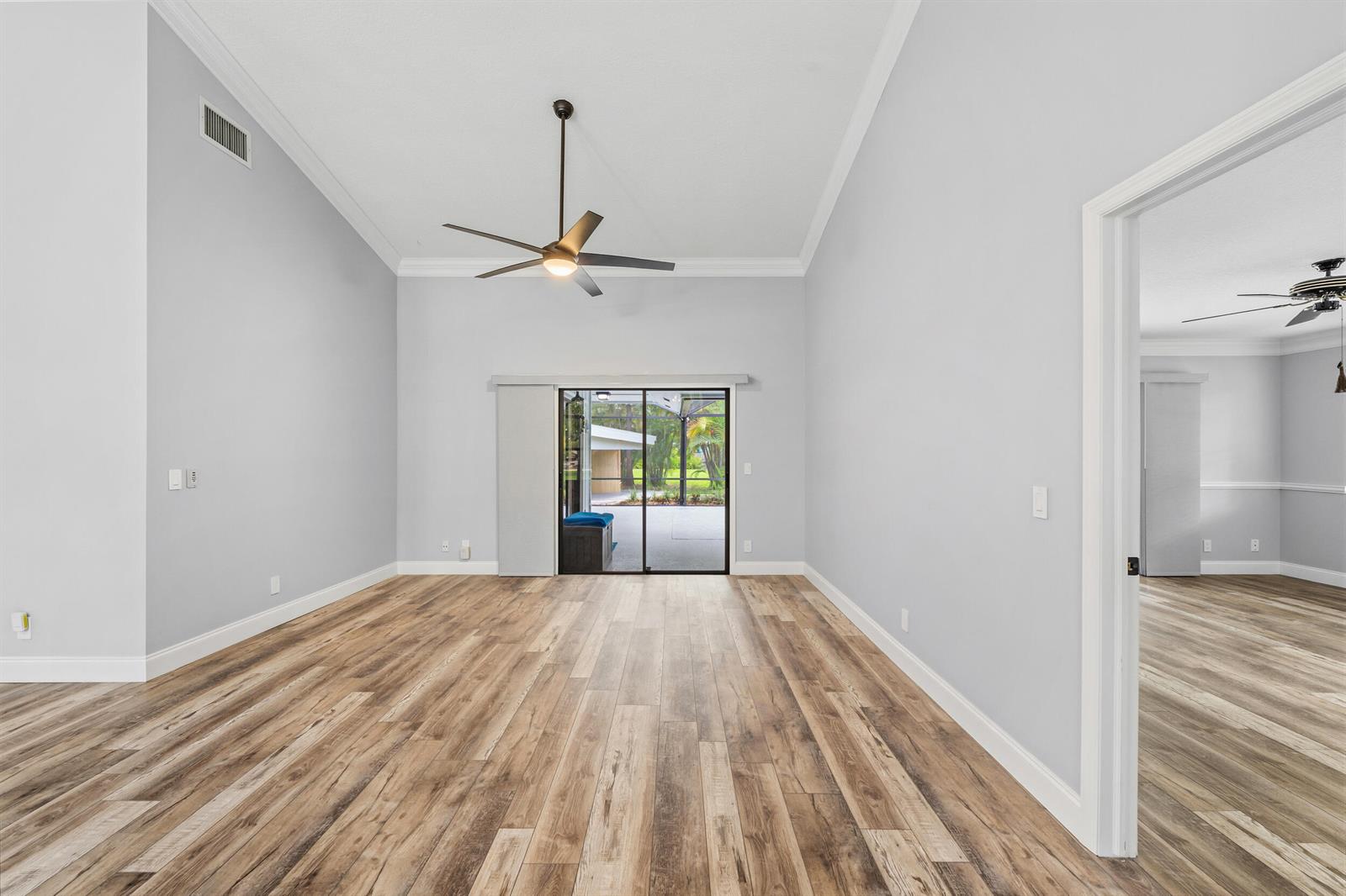 An empty room with light gray walls, wood-look flooring, a ceiling fan, and sliding doors — 15833 118th Trail N, Jupiter FL 33478, JUPITER, FL