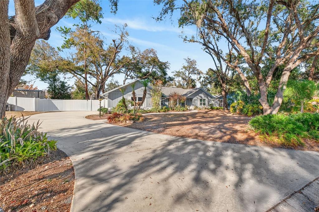 A single-story house with a concrete driveway and mature trees in a landscaped yard — 1406 BIG OAK COURT, BRANDON, FL