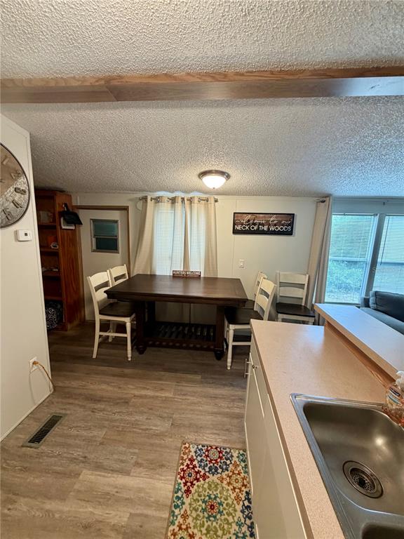 A dining area with a wooden table and chairs sits adjacent to a kitchen sink — 20445 NE 144TH LANE, FORT MC COY, FL