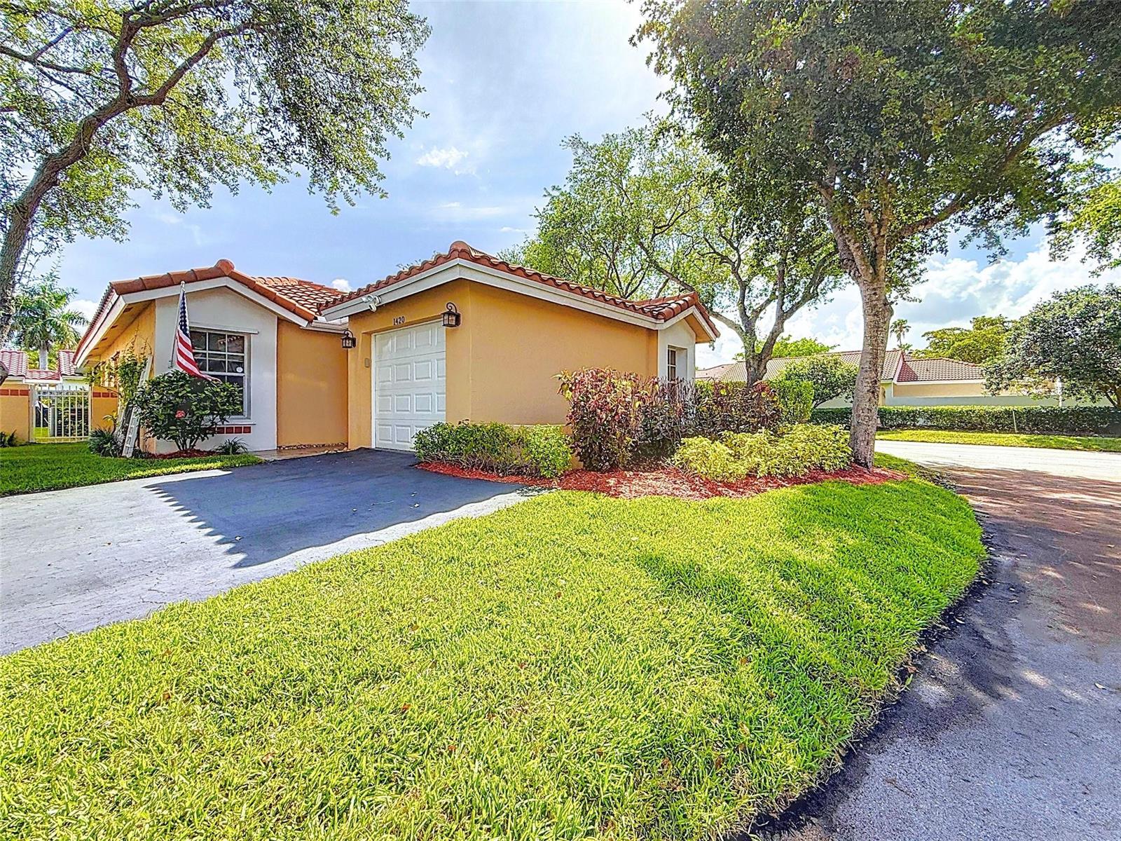 A single-story house with a tan exterior, tile roof, and a paved driveway — 1420 Seagrape Circle, Weston FL 33326, WESTON, FL