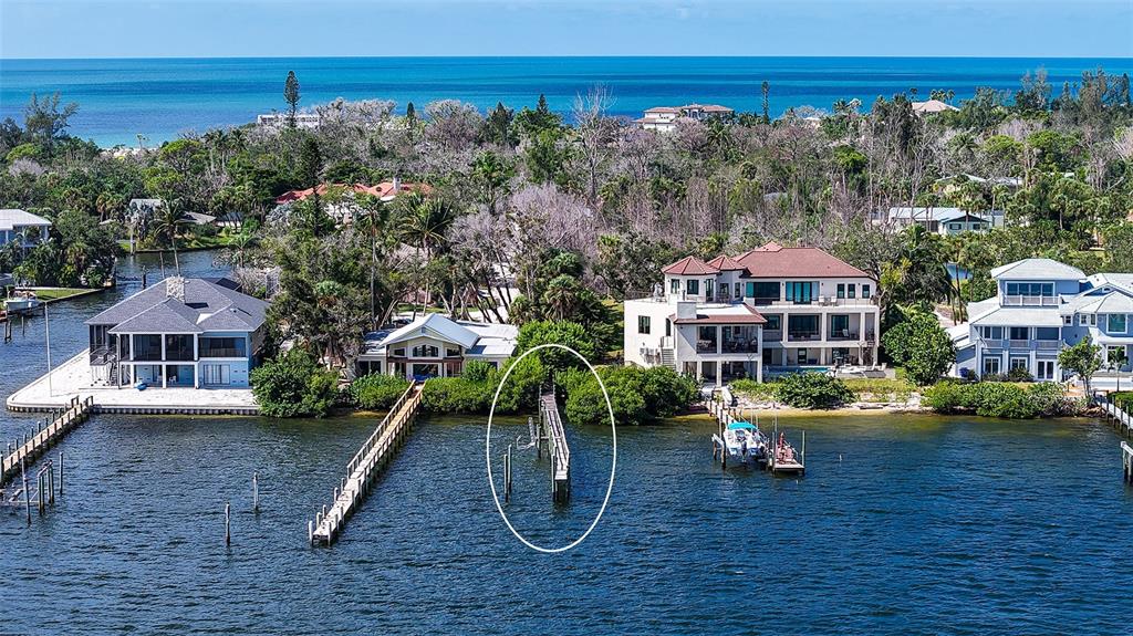 An aerial view shows waterfront homes with private docks extending into the bay — 7401-A MIDNIGHT PASS ROAD UNIT A, SARASOTA, FL