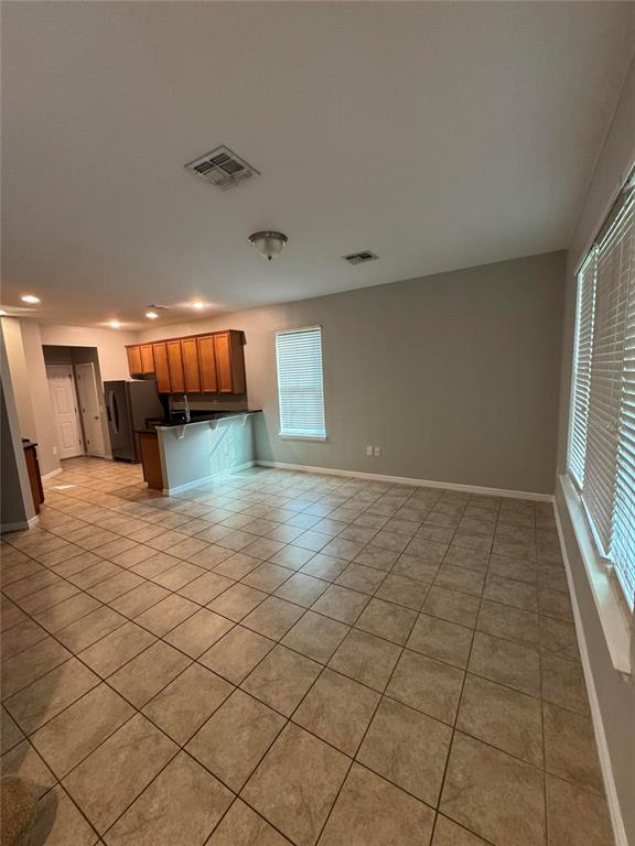 A kitchen with wood cabinets and a breakfast bar overlooks an open tiled dining area — 11938 SILVERLAKE PARK DRIVE, WINDERMERE, FL