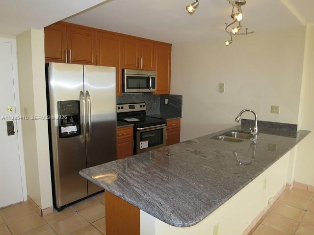 A kitchen features wood cabinets, stainless steel appliances, and a granite-topped island — 600 NE 36th St # 517, Miami FL 33137, MIAMI, FL