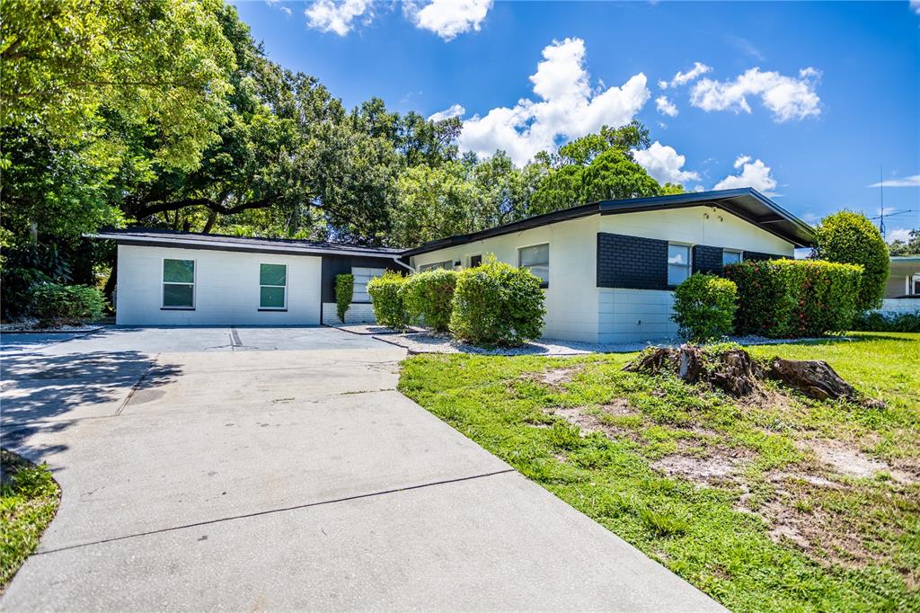 A single-story house with a white exterior, black accents, and a concrete driveway — 1213 CORBETT LANE, ORLANDO, FL