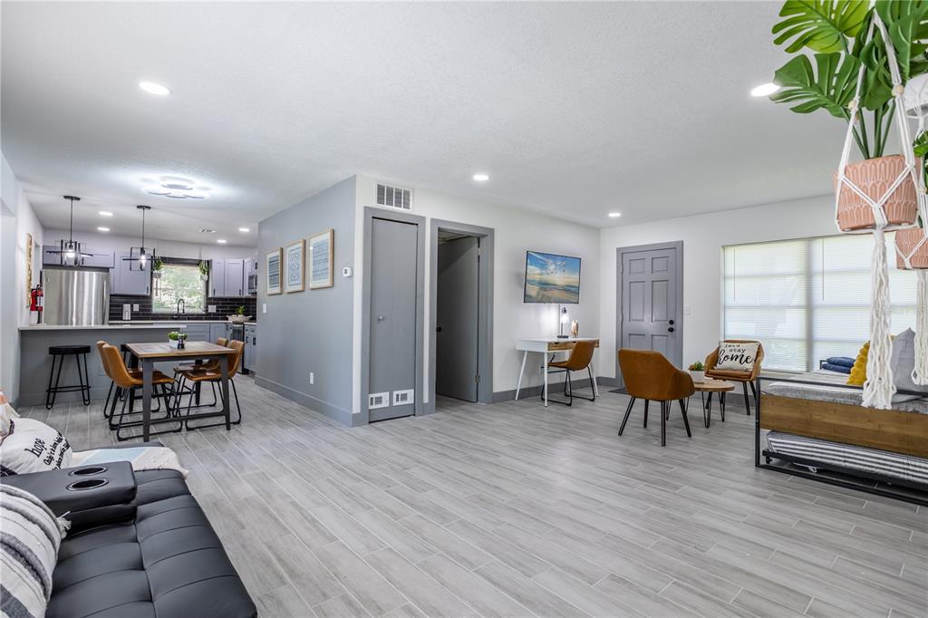 An open-concept living room and kitchen feature gray tile flooring and modern gray cabinetry — 1213 CORBETT LANE, ORLANDO, FL