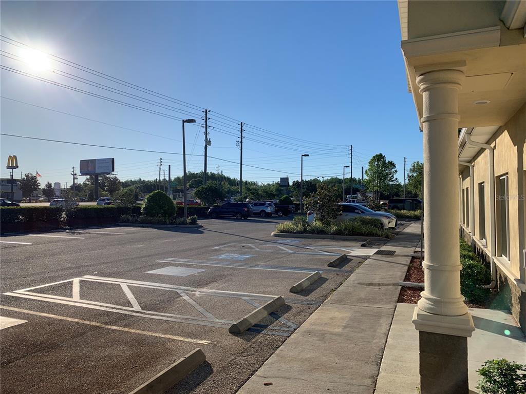 A parking lot with marked handicap spaces sits in front of a building with columns — 5140 DEER PARK DRIVE, NEW PORT RICHEY, FL