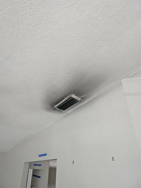 A ceiling air vent surrounded by dark, soot-like staining in a white-painted room — 1929 SEDGEFIELD STREET, BRANDON, FL
