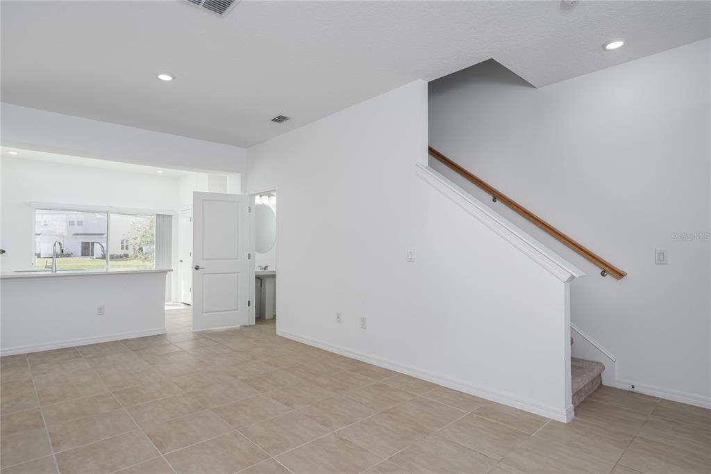 An interior view shows a tiled living area with a staircase and an adjacent kitchen — 6106 FAIRMONT LANE, PALMETTO, FL