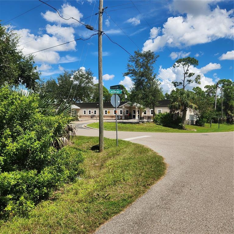 A street corner view shows a single-story building behind a utility pole and street signs — 1587 CASTLEROCK LANE, PORT CHARLOTTE, FL