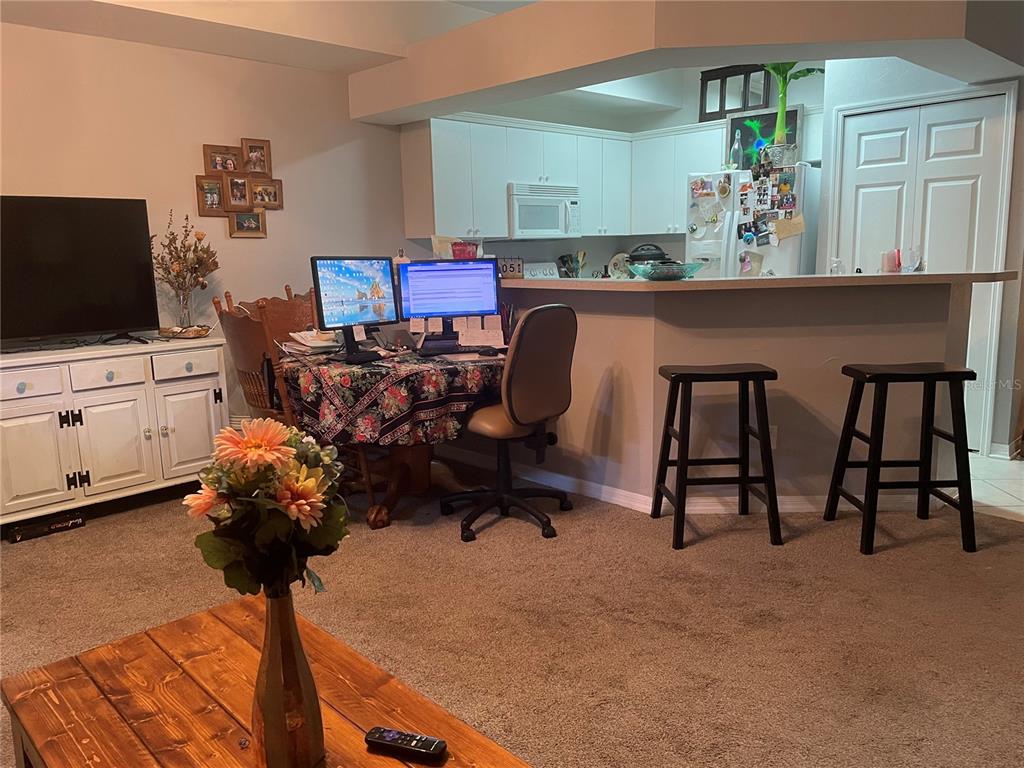 A kitchen with white cabinets, white appliances, and light-colored countertops and tile flooring — 4945 NW 1ST PLACE, GAINESVILLE, FL