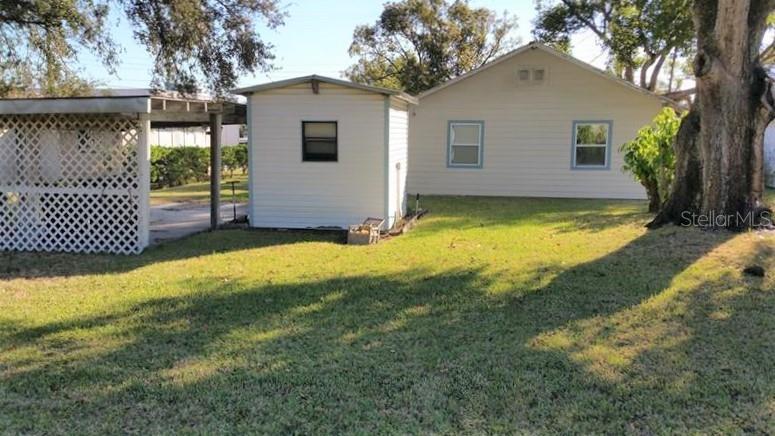 A backyard view shows a house, a small detached shed, and a covered patio area — 608 LEMON STREET, AUBURNDALE, FL