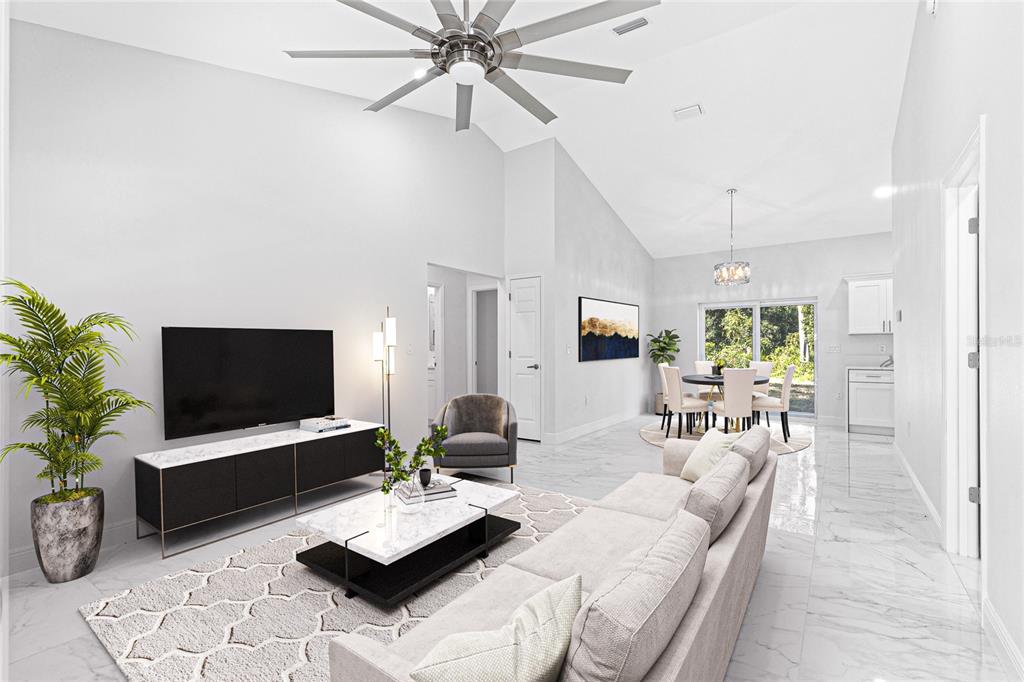 A living room and dining area feature vaulted ceilings, white marble floors, and modern furniture — 15223 SE 61ST COURT, SUMMERFIELD, FL