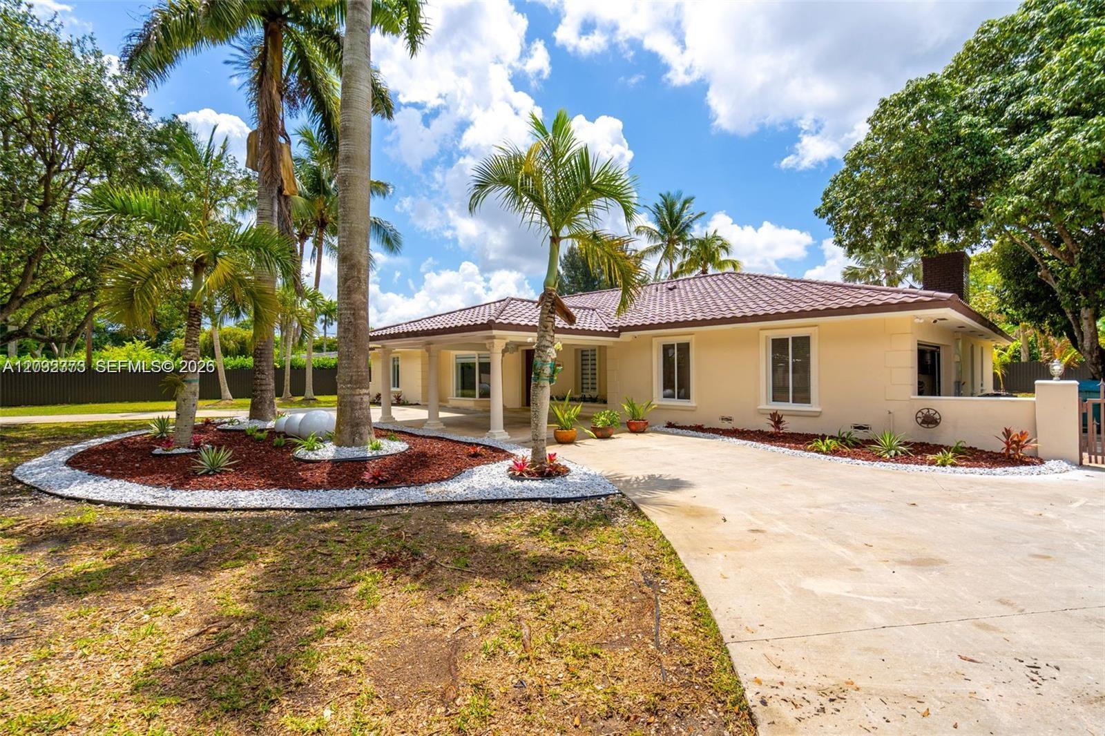 A single-story house with a tiled roof, palm trees, and a concrete driveway — 18370 SW 212th St, Miami FL 33187, MIAMI, FL