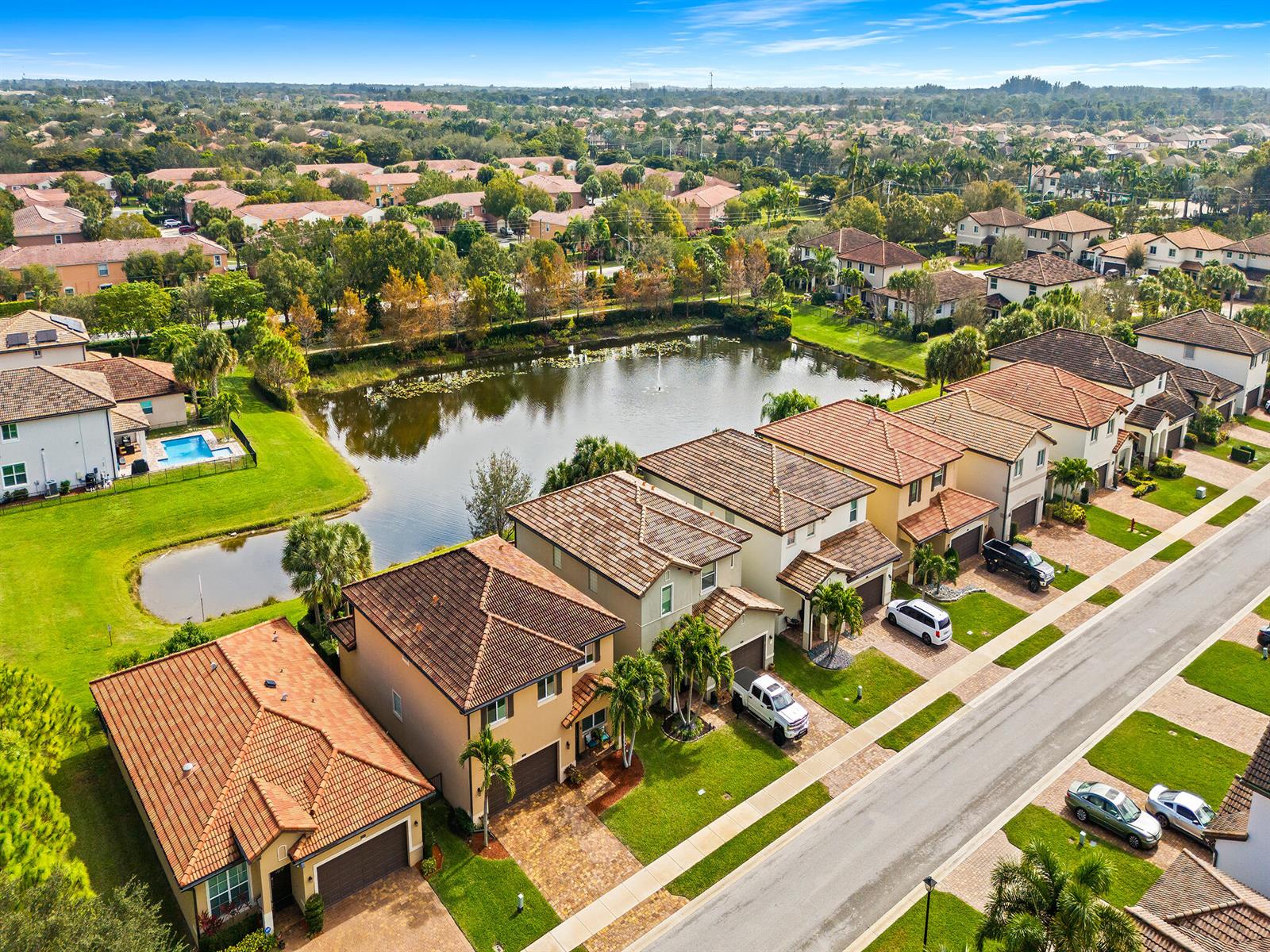 An aerial view shows a row of suburban houses bordering a small lake — 6830 Langdon Way, Lake Worth FL 33463, LAKE WORTH, FL