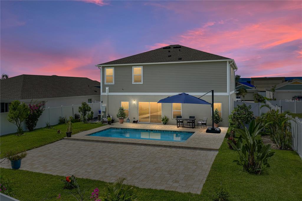 The rear exterior of a two-story house features a swimming pool and a paved patio — 12756 TANNENCREST DRIVE, RIVERVIEW, FL