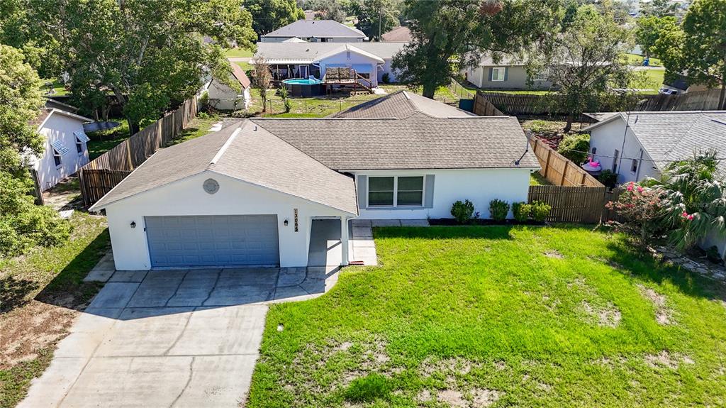 An aerial view of a single-story white house with a garage and a grassy yard — 13065 PIRATE LANE, SPRING HILL, FL