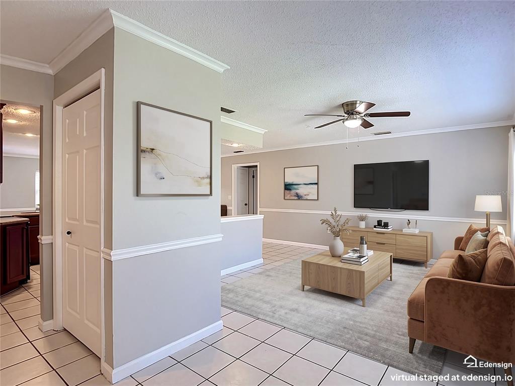 This virtual staging shows a living room with light gray walls, tile flooring, and a sofa — 13065 PIRATE LANE, SPRING HILL, FL