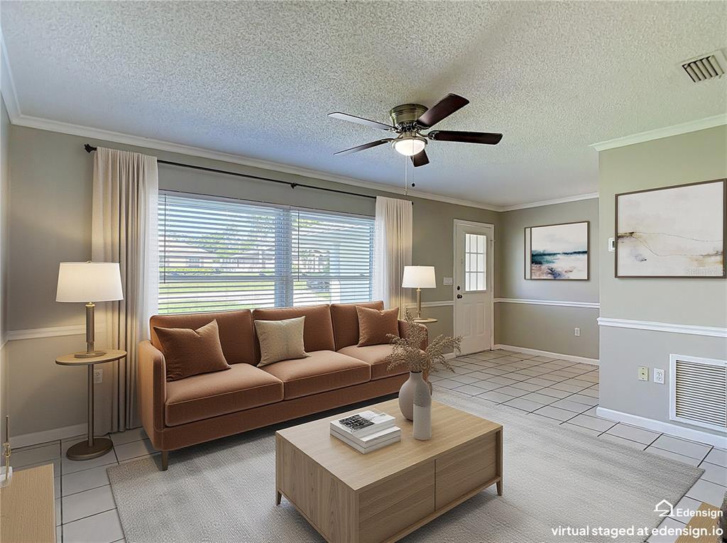 This virtual staging shows a living room with tile floors, a brown sofa, and a ceiling fan — 13065 PIRATE LANE, SPRING HILL, FL