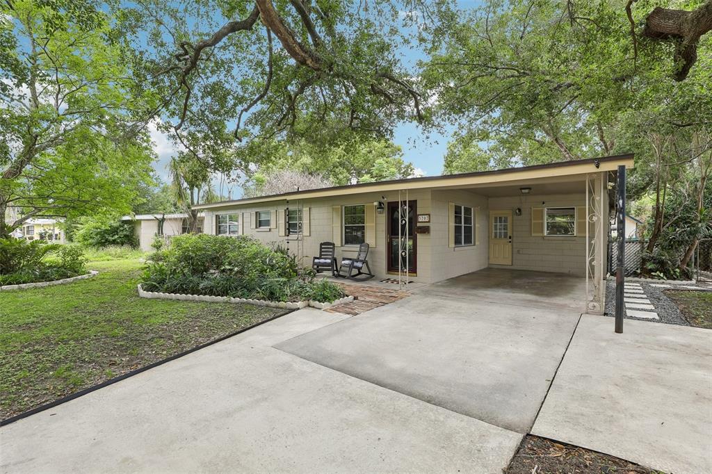 A single-story house with a beige exterior, a front carport, and a large shade tree — 3707 MARCH AVENUE, ORLANDO, FL