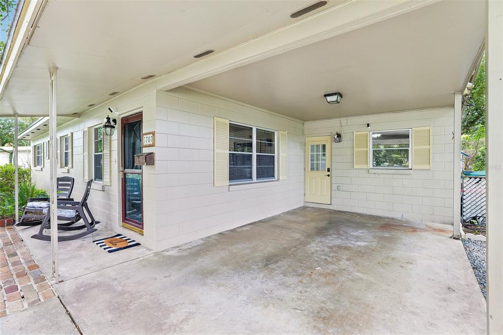 A concrete carport with a covered patio area, white block walls, and two exterior doors — 3707 MARCH AVENUE, ORLANDO, FL