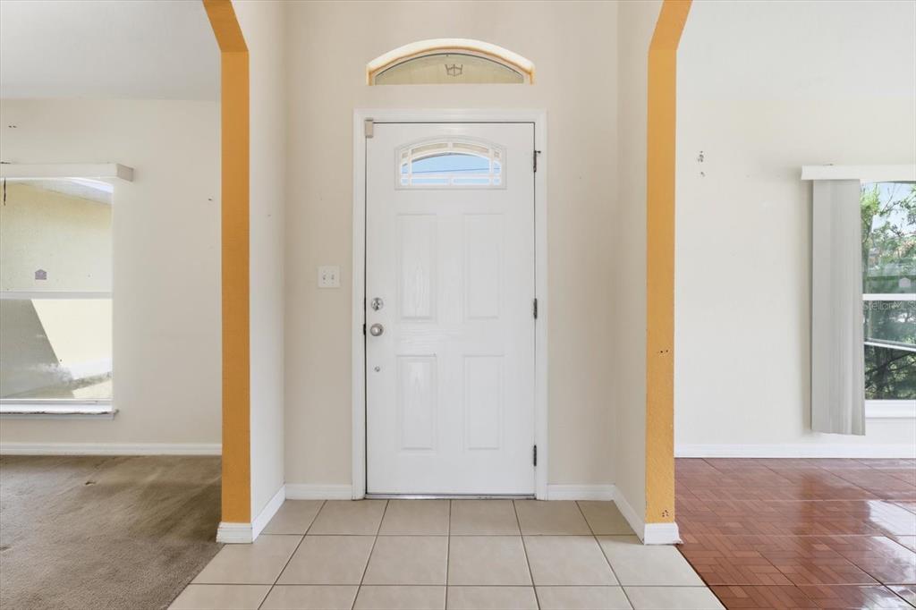An entryway features a white front door with a transom window and tiled flooring — 2614 SW 165TH STREET ROAD, OCALA, FL