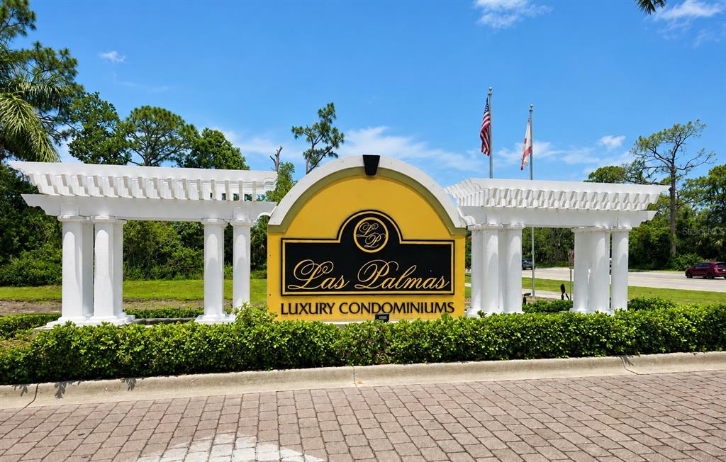 A white stone monument sign for Las Palmas Luxury Condominiums stands before a landscaped entrance — 5711 BENTGRASS DRIVE UNIT 19-203, SARASOTA, FL