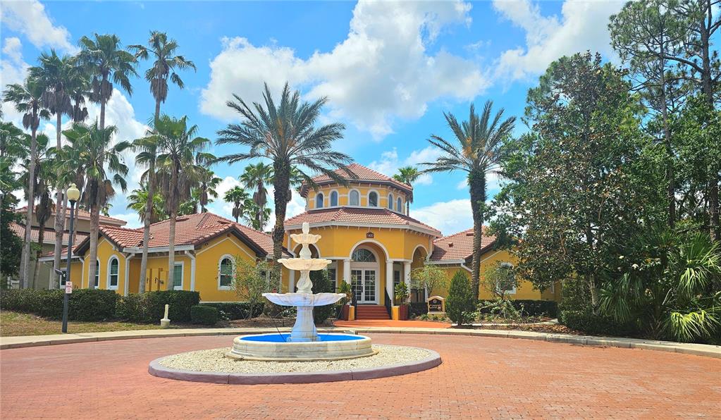 A yellow building with a tiled roof features a central fountain in a circular driveway — 5711 BENTGRASS DRIVE UNIT 19-203, SARASOTA, FL