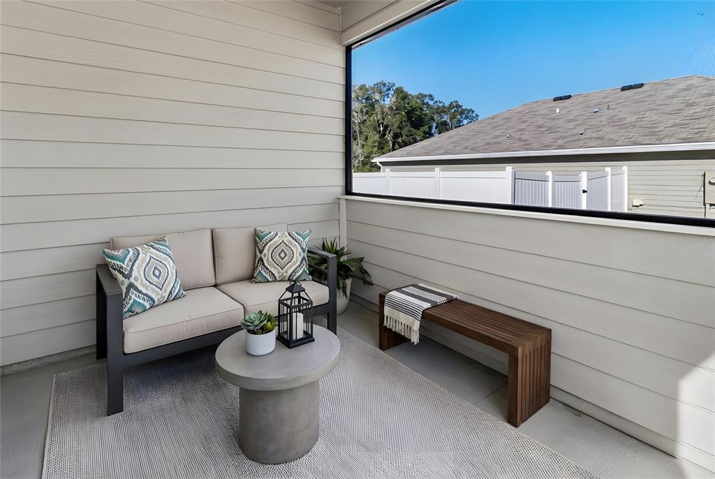 A screened-in porch features a loveseat, a small round table, and a wooden bench — 22608 NW 196TH LANE, HIGH SPRINGS, FL