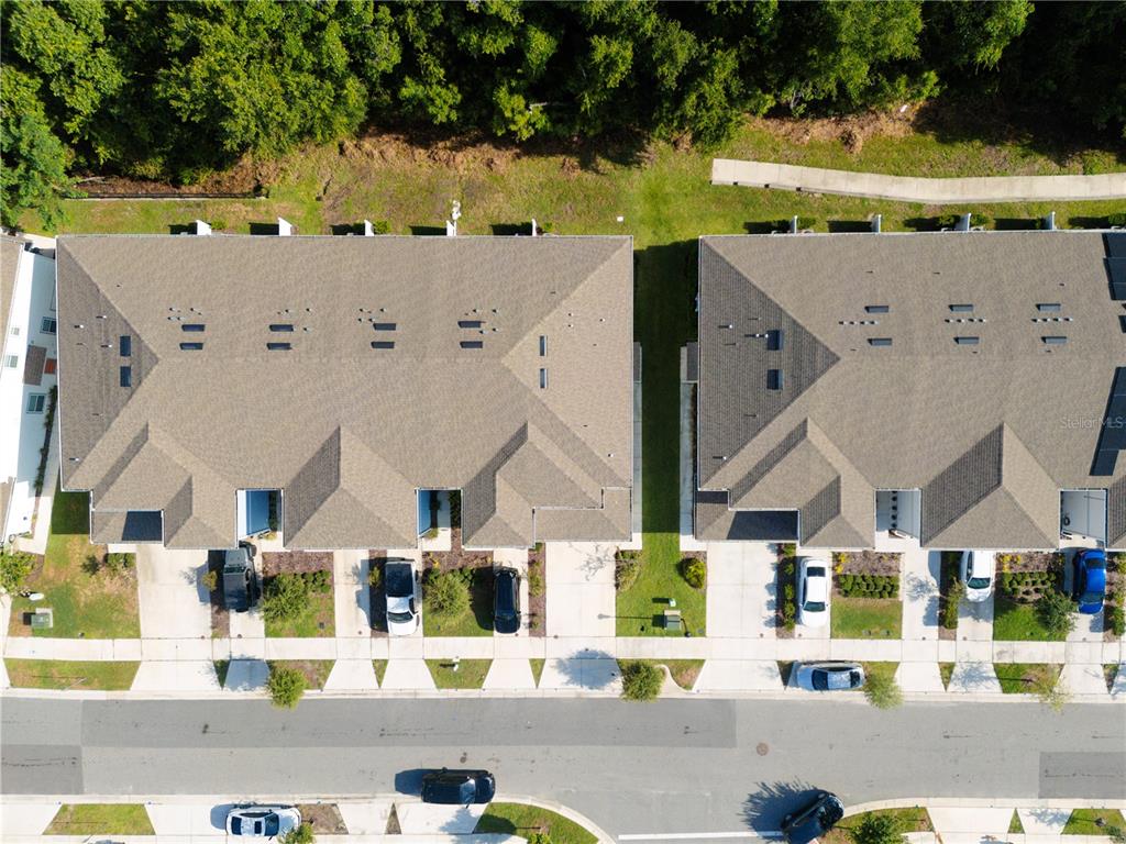An aerial view shows two multi-unit townhome buildings with driveways and parked cars — 4609 SPARKLING SHELL AVENUE, KISSIMMEE, FL