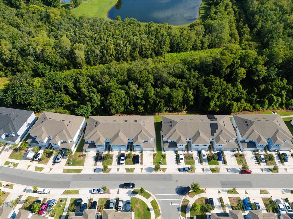 An aerial view shows a row of townhomes with driveways facing a curved residential street — 4609 SPARKLING SHELL AVENUE, KISSIMMEE, FL