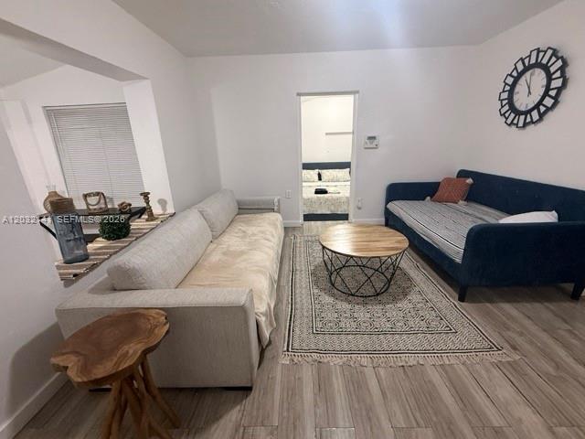 A living room features a light sofa, a blue daybed, and a round wooden coffee table — 1419 NW 44th St, Miami FL 33142, MIAMI, FL
