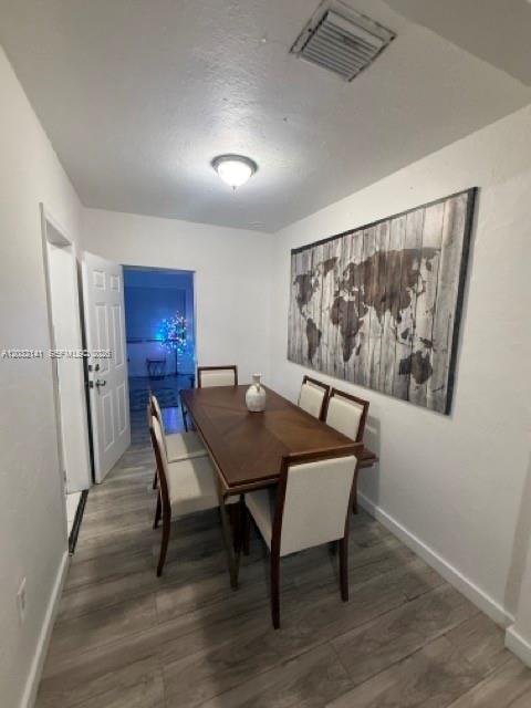 A dining room features a wooden table, six chairs, and a large world map wall art — 1419 NW 44th St, Miami FL 33142, MIAMI, FL