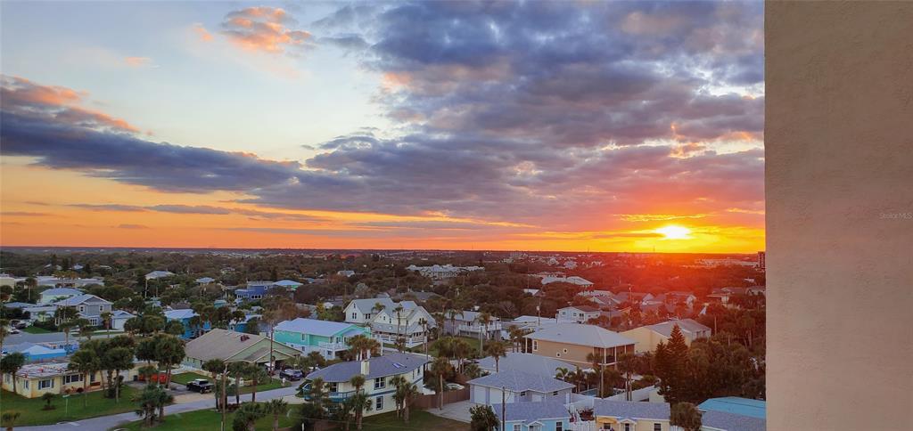 An elevated view of a residential neighborhood at sunset with a bright orange horizon — 601 N ATLANTIC AVENUE UNIT 8070, NEW SMYRNA BEACH, FL