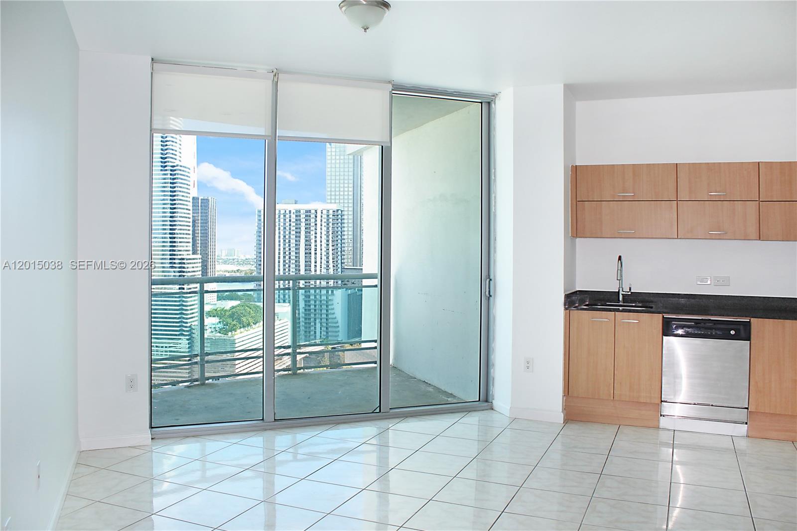 A kitchen with light wood cabinets and a balcony overlooking a city skyline — 350 S Miami Ave # 2713, Miami FL 33130, MIAMI, FL
