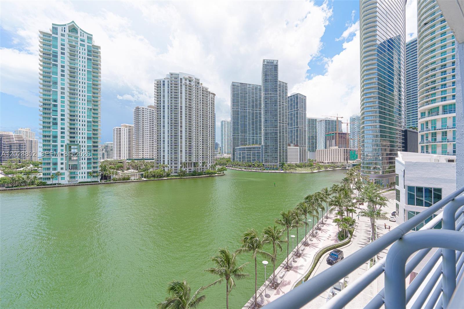 A high-angle view shows a waterfront canal surrounded by modern high-rise apartment buildings — 325 S Biscayne Blvd # 821, Miami FL 33131, MIAMI, FL