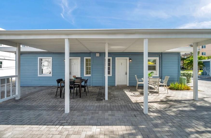 A blue building with two doors and a covered patio area with outdoor furniture — 602 POINSETTIA AVENUE, CLEARWATER BEACH, FL