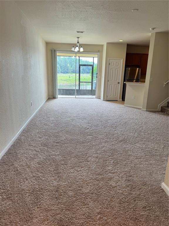 A living room features a beige sofa, wooden coffee table, and sliding glass patio doors — 2543 OLD KENT CIRCLE, KISSIMMEE, FL