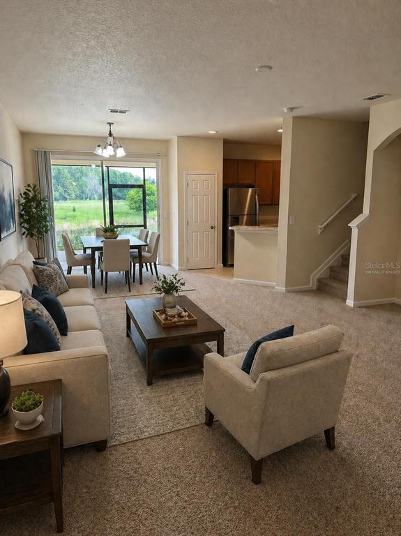 A carpeted living room features an arched entryway, a white door, and a front entrance — 2543 OLD KENT CIRCLE, KISSIMMEE, FL