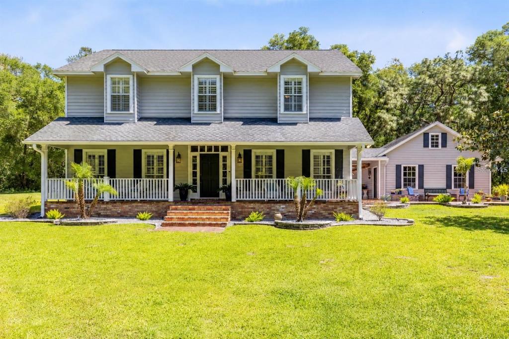 A two-story house with a large front porch, dormer windows, and an attached side building — 5787 & 5789 N APOPKA VINELAND ROAD, ORLANDO, FL