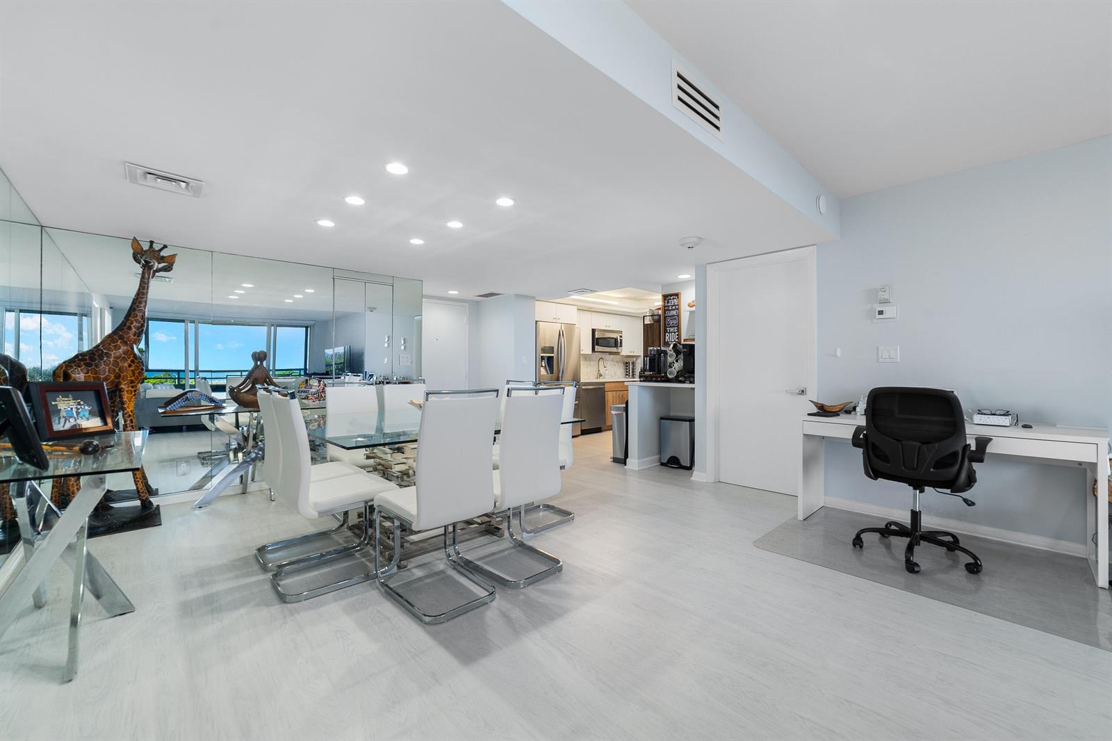A dining area with a glass table and chairs sits beside a home office space — 4101 N Ocean Boulevard # 505, Boca Raton FL 33431, BOCA RATON, FL