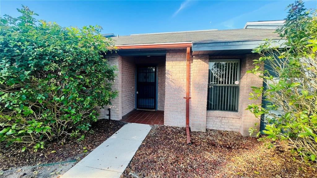 A brick exterior home features a front entrance, a walkway, and surrounding landscaping — 2531 KING OAK CIRCLE, ST CLOUD, FL